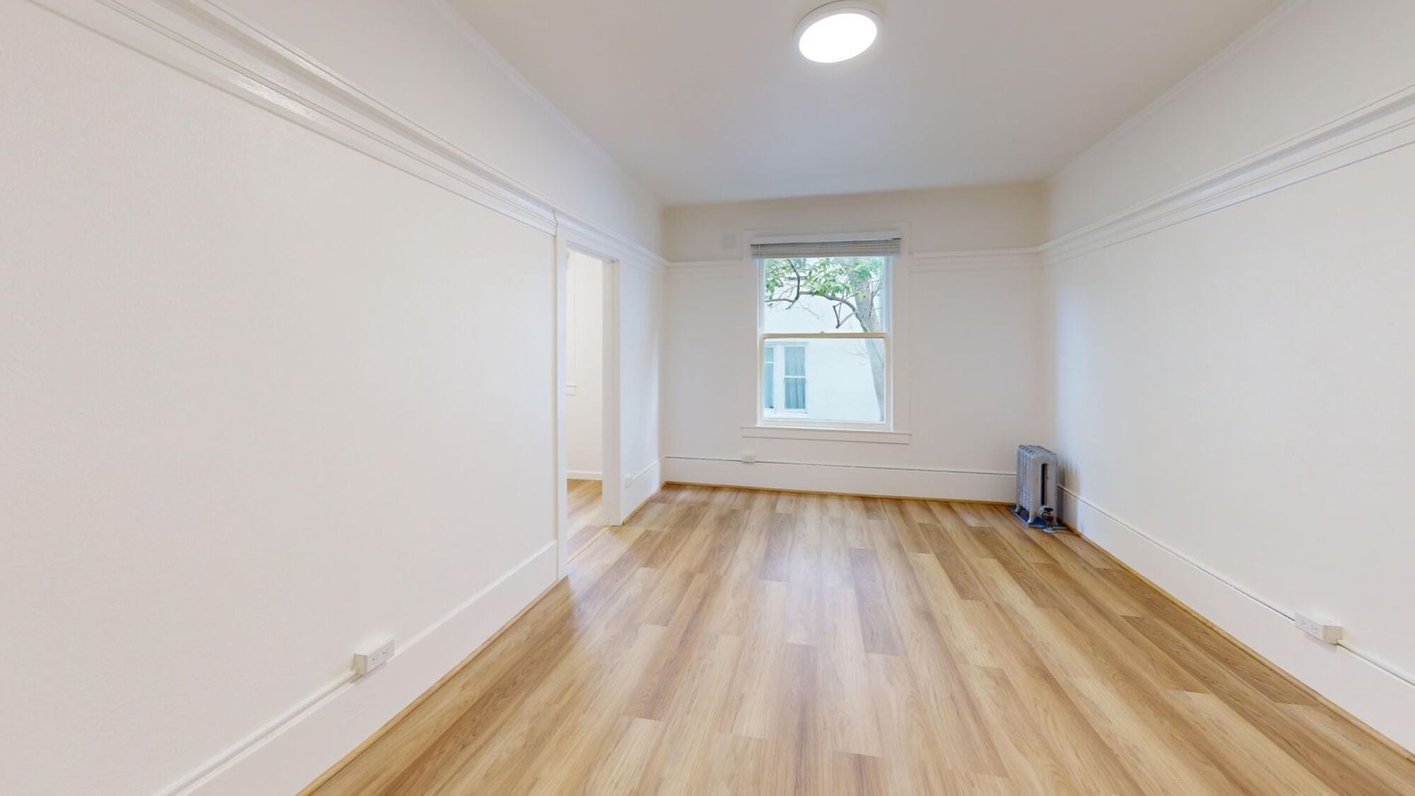 A room with wooden floors and white walls.