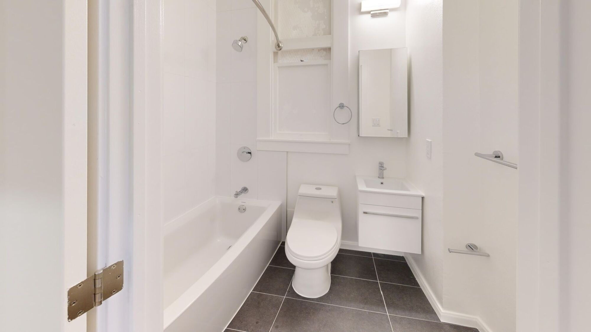 A white bathroom with a tub, toilet, and sink.