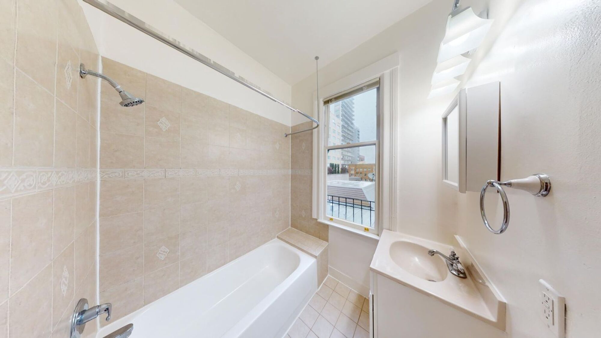 A bathroom with a white tub, sink, and shower.