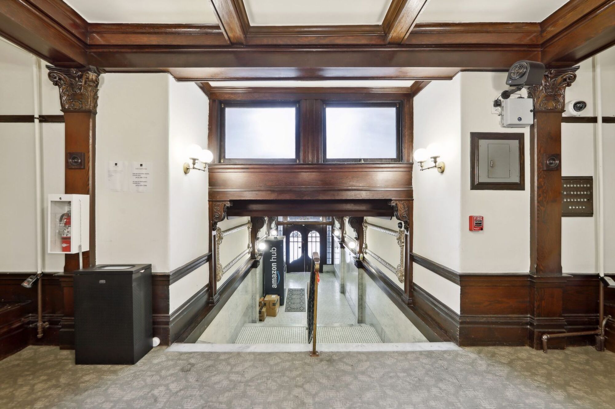 A hallway with a wooden ceiling and a glass door.