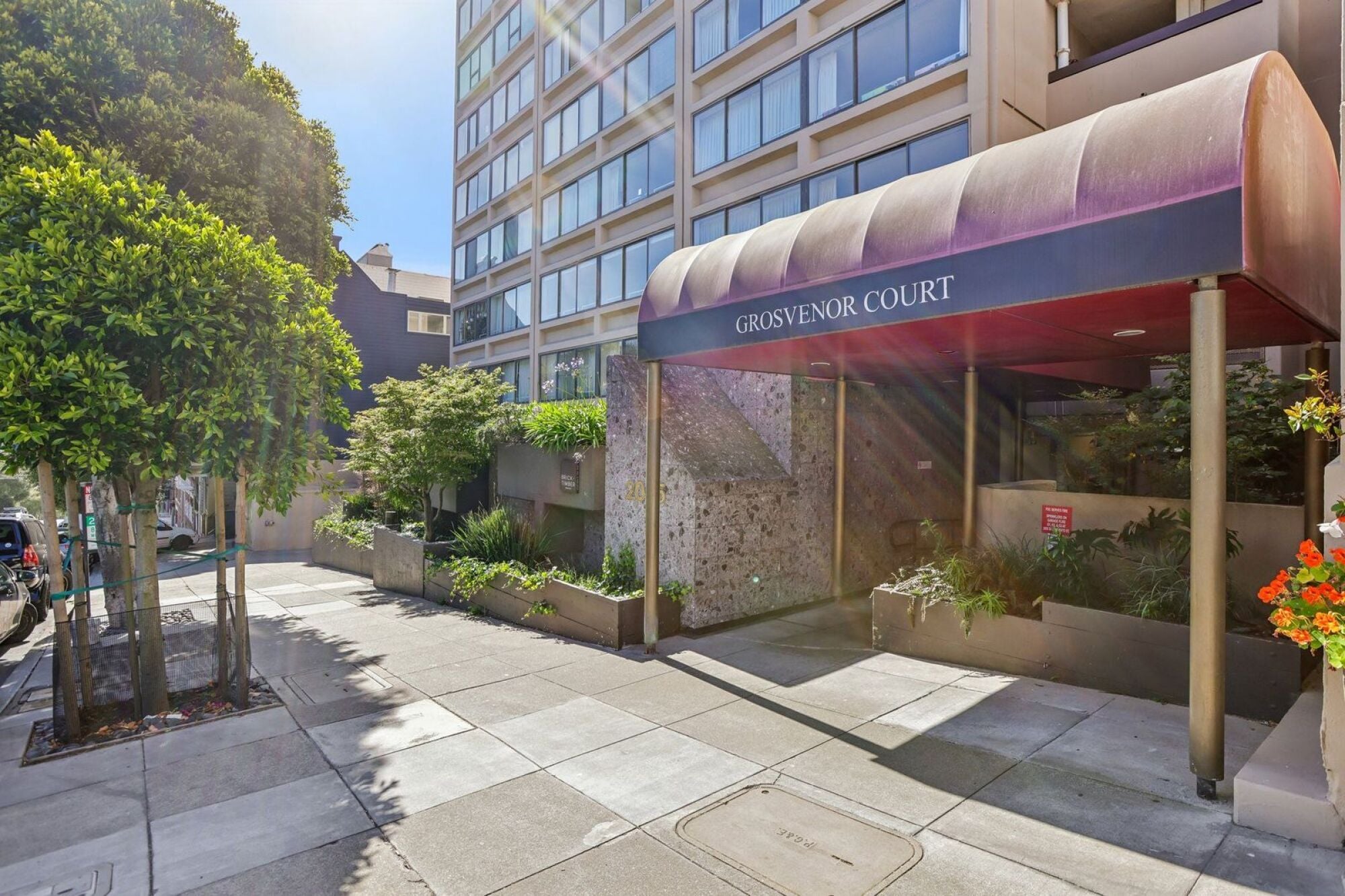 The entrance to Grosvenor Court is framed by a row of trees.