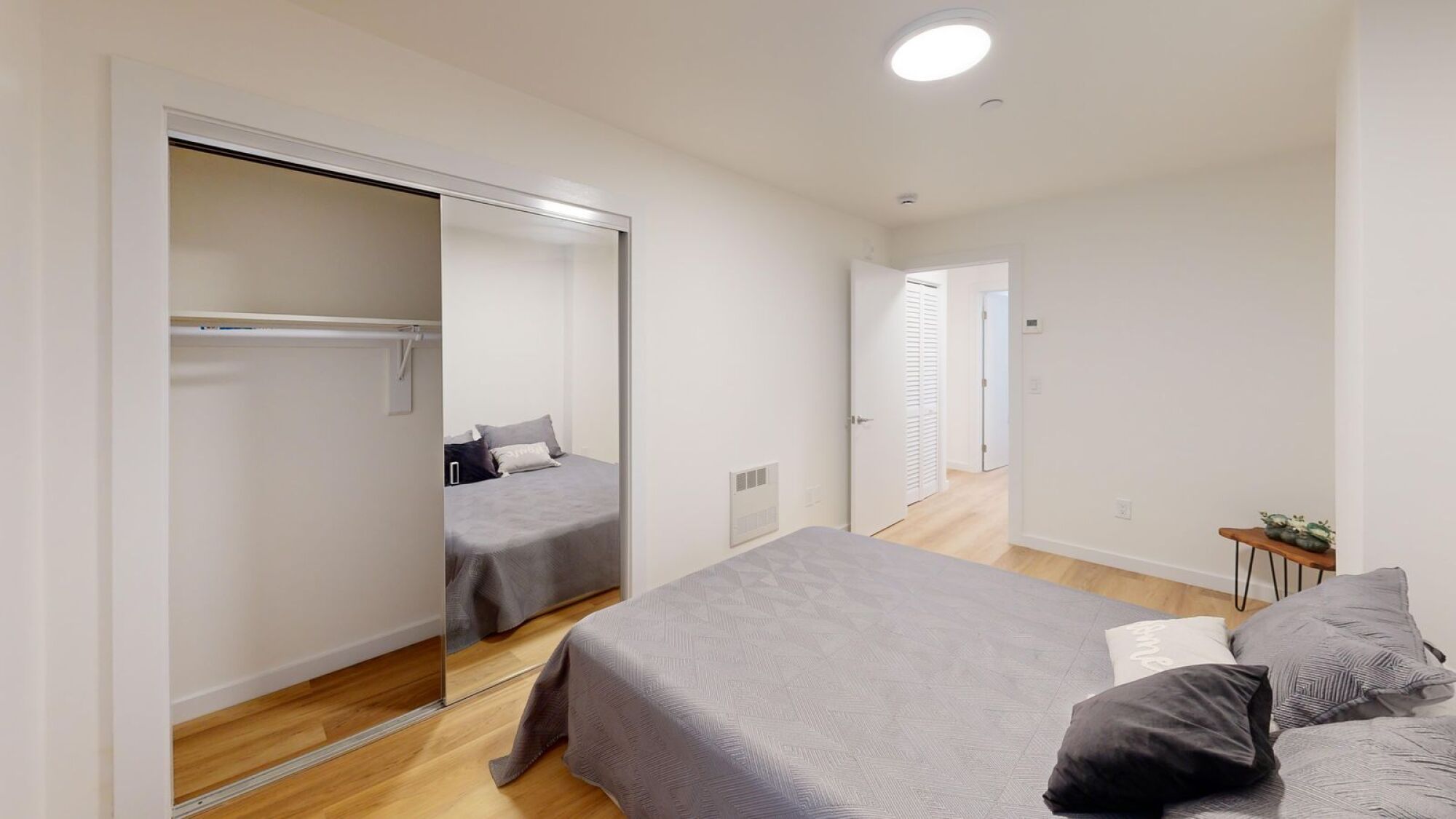 A bedroom with a bed and a sliding door.