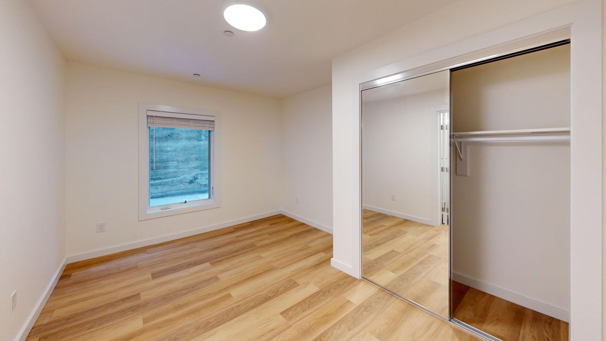 A room with a wooden floor and a window.