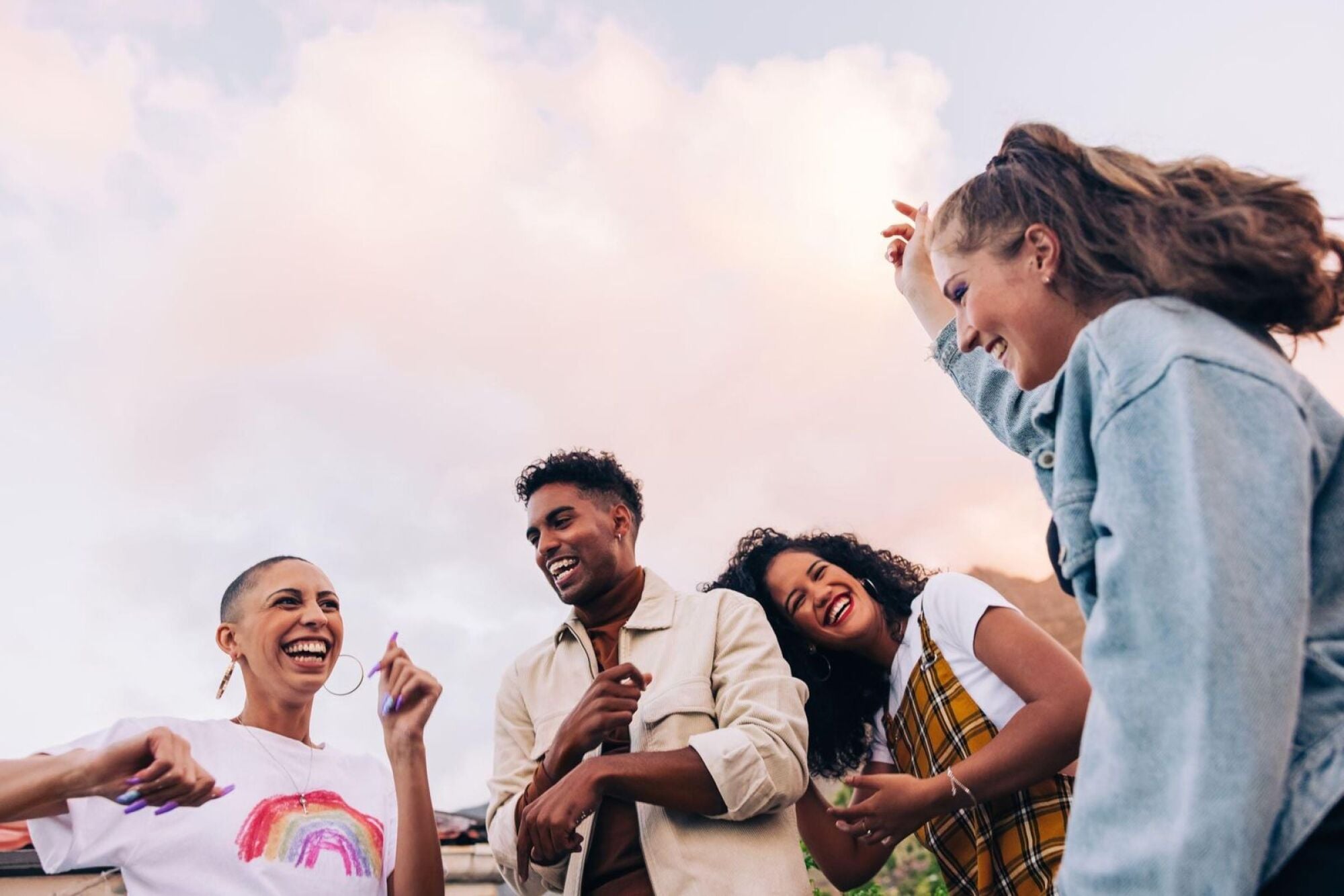 A joyful group of friends laughing and enjoying each other's company in a lively outdoor setting.