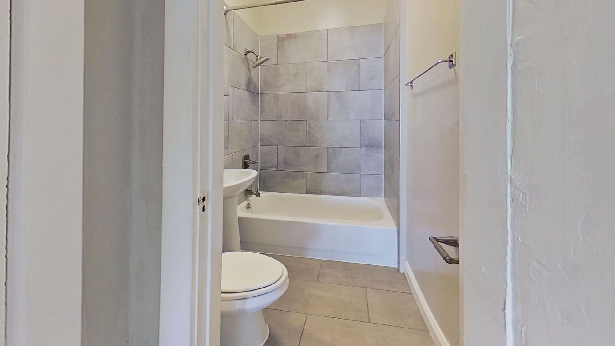 A white bathroom with a toilet, tub, and shower.