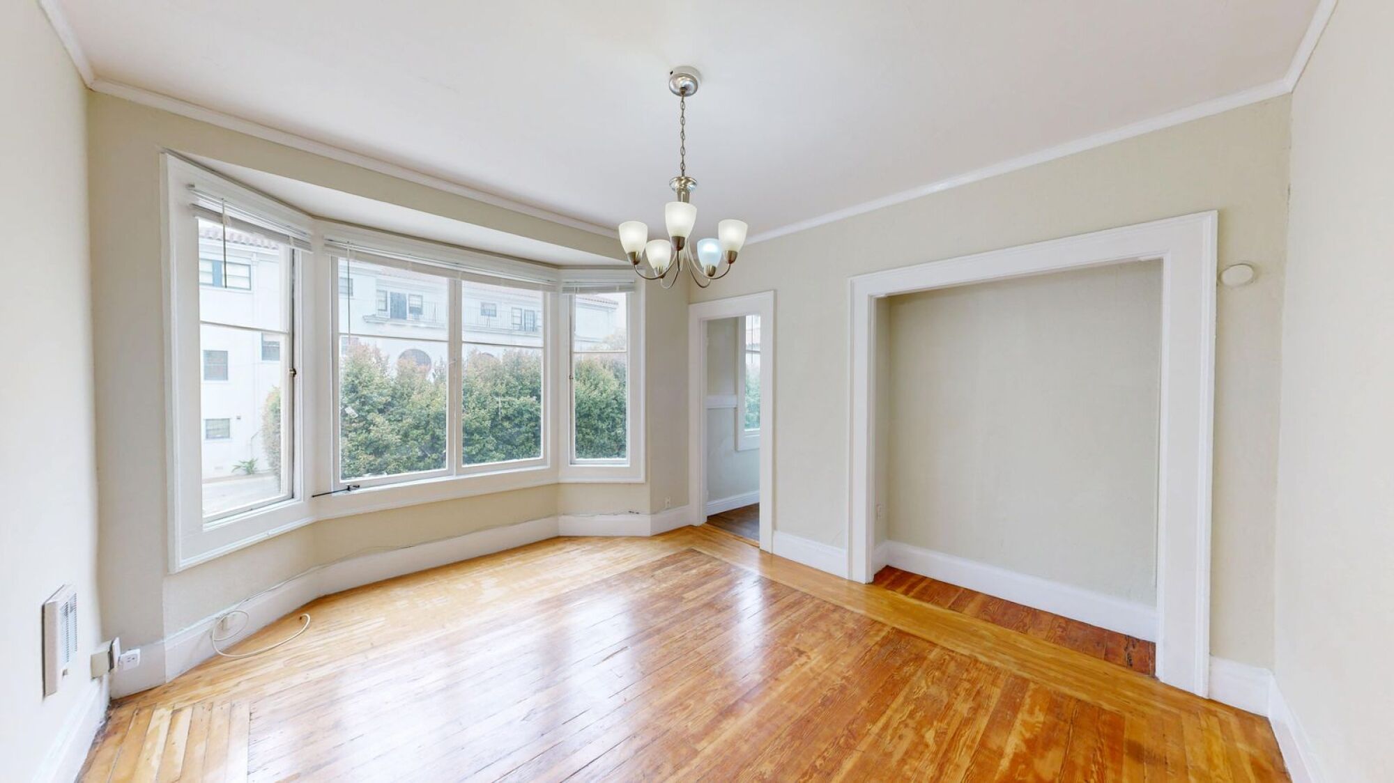 A room with a chandelier and a large window.