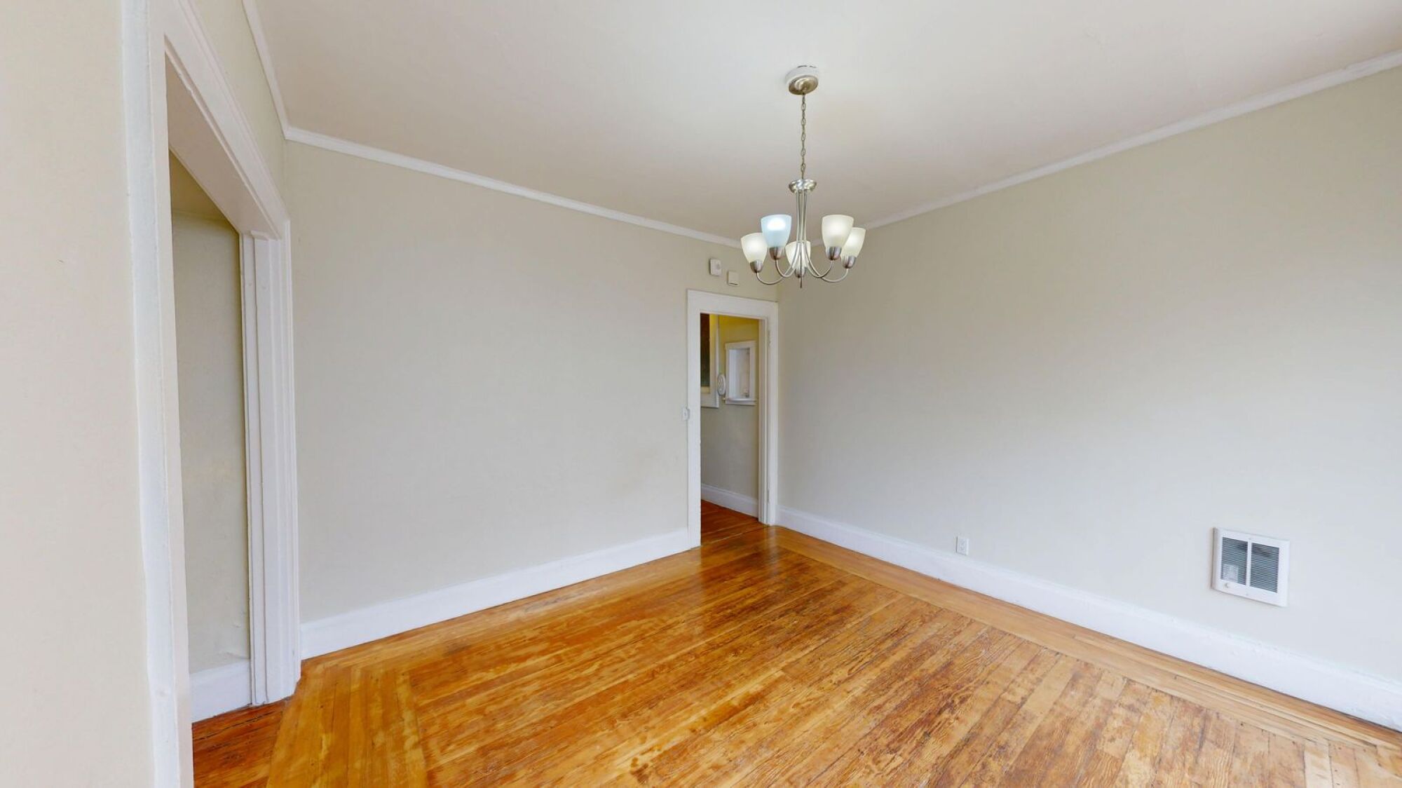 A room with wooden floors and a chandelier.