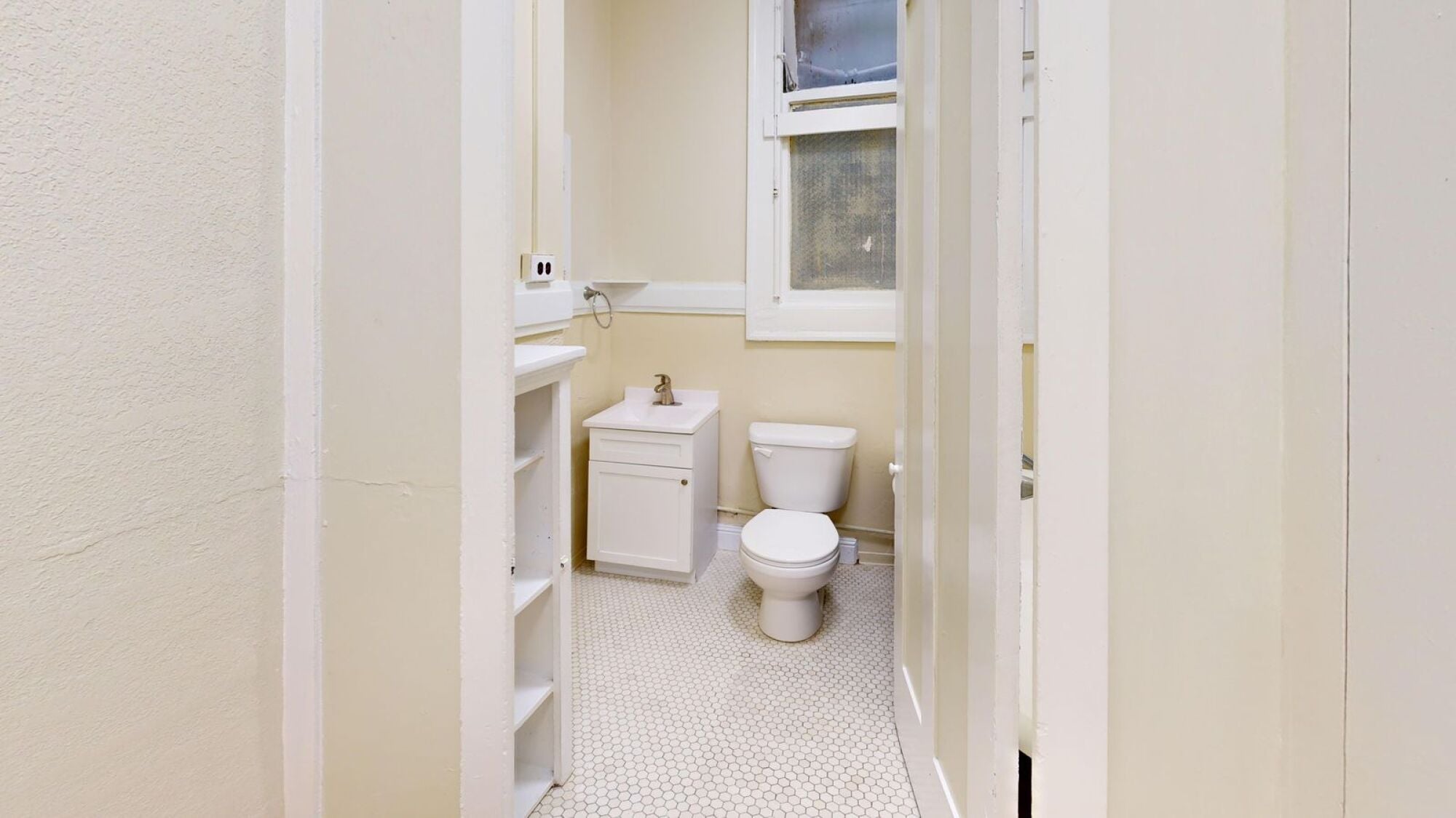 A small bathroom with a toilet and a cabinet.