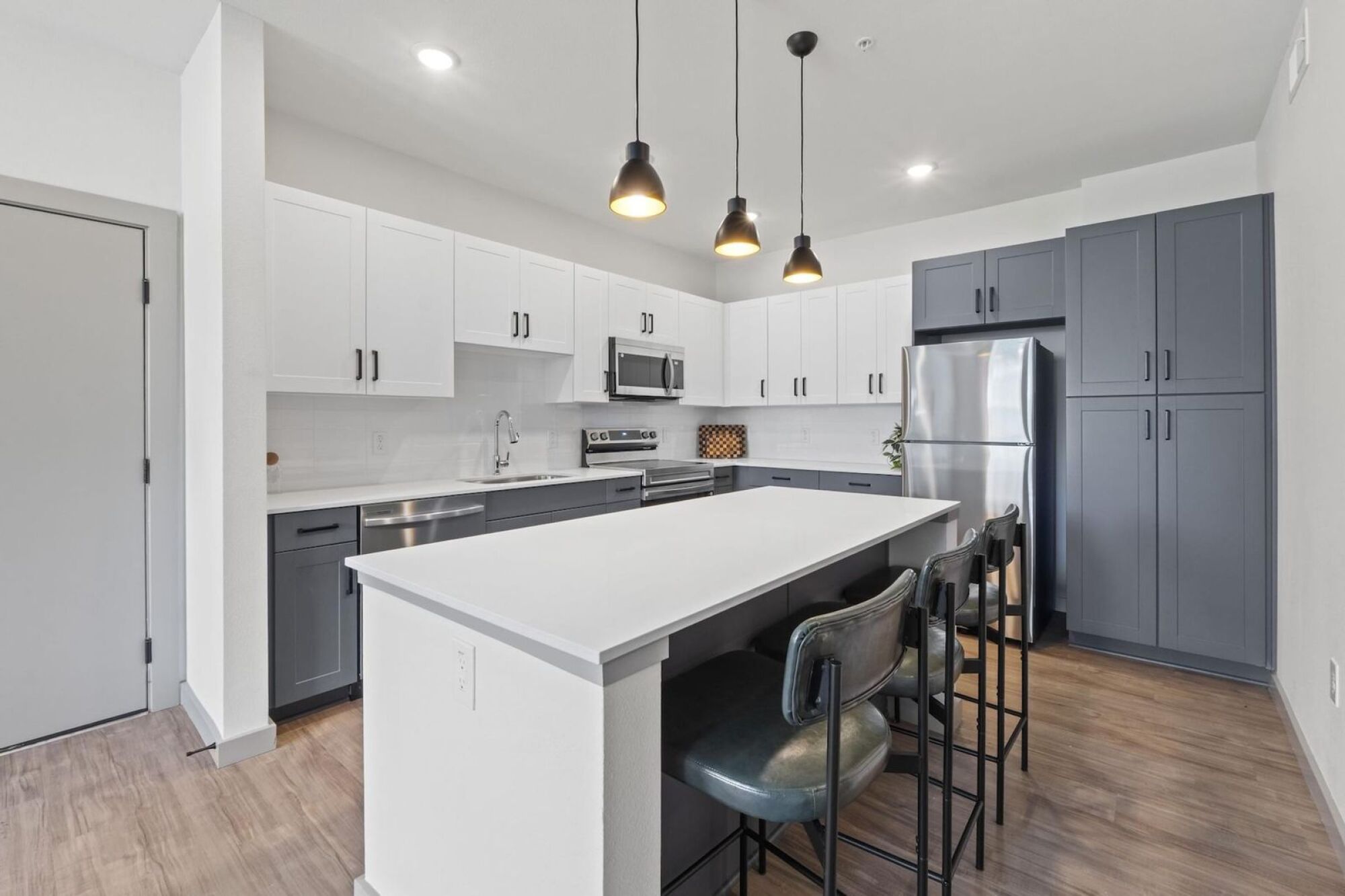 Modern Apartment Kitchen with stainless steel appliances, two-toned cabinetry, and quartz countertops in Austin TX