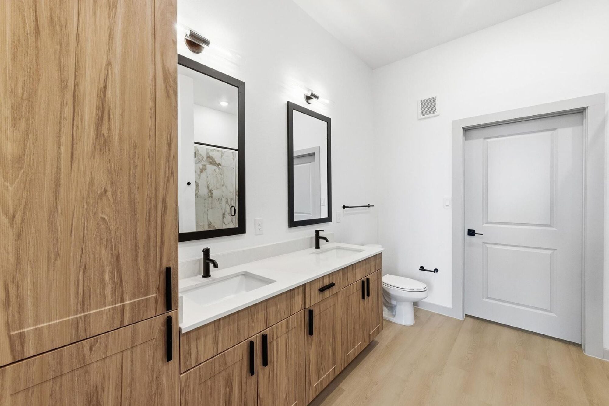A master bathroom with double sinks and designer fixtures at Wixby House in Austin, Texas.