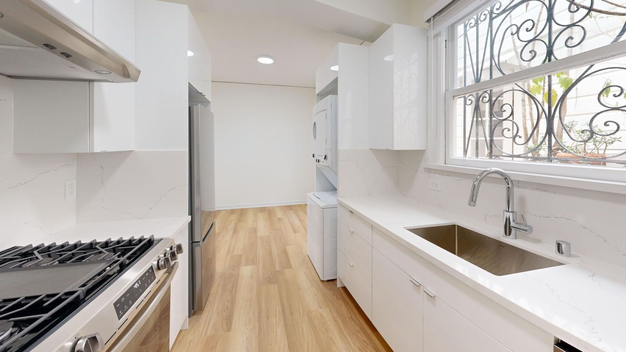 A modern kitchen with a stove, sink, and cabinets.