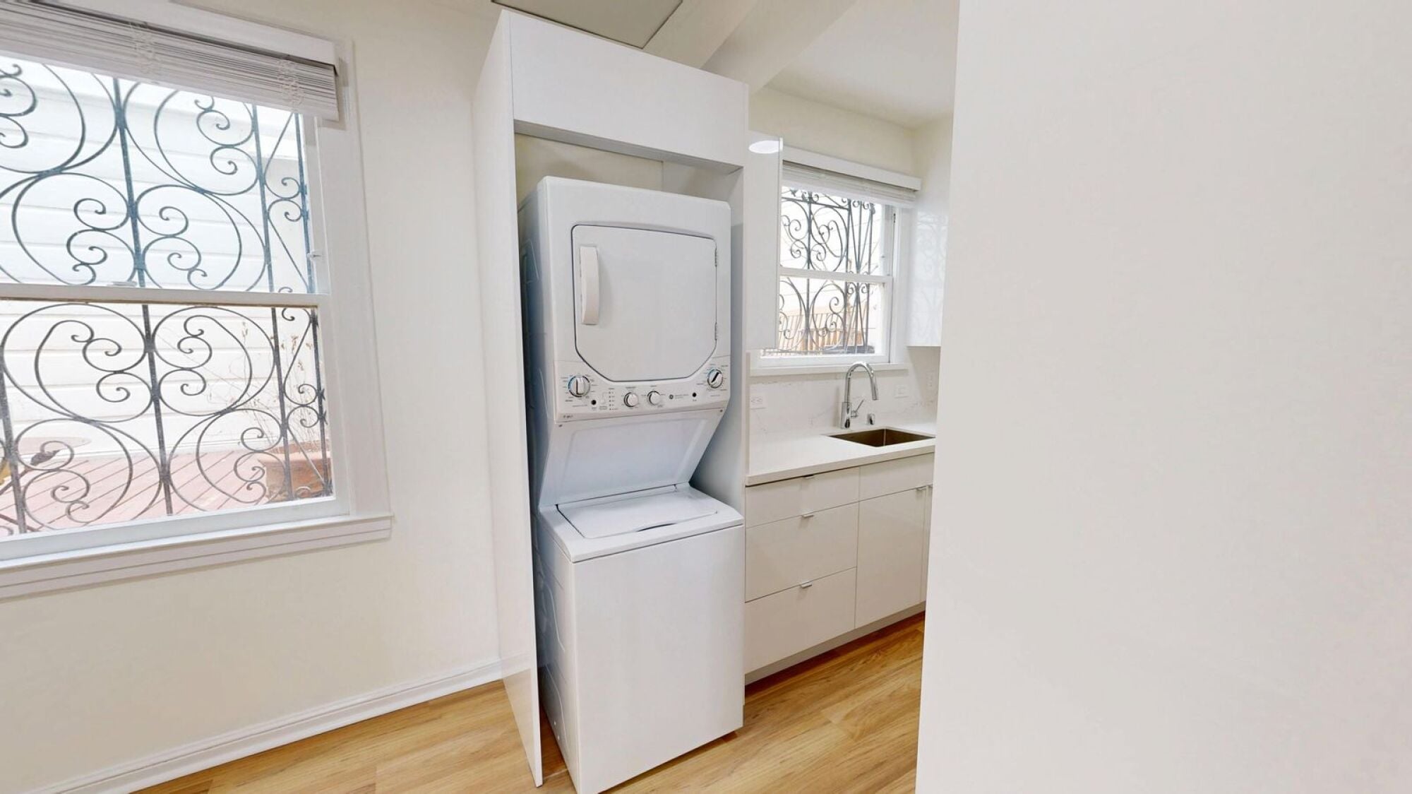 A white washing machine is in a small laundry room.