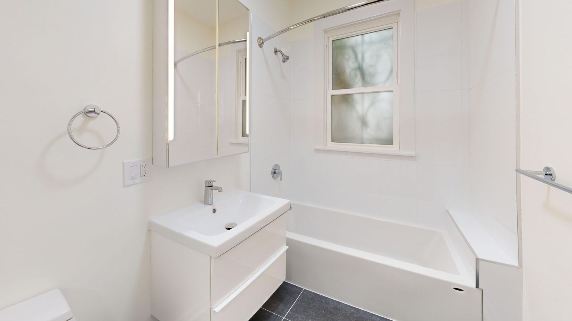 A white bathroom with a sink, toilet, and bathtub.