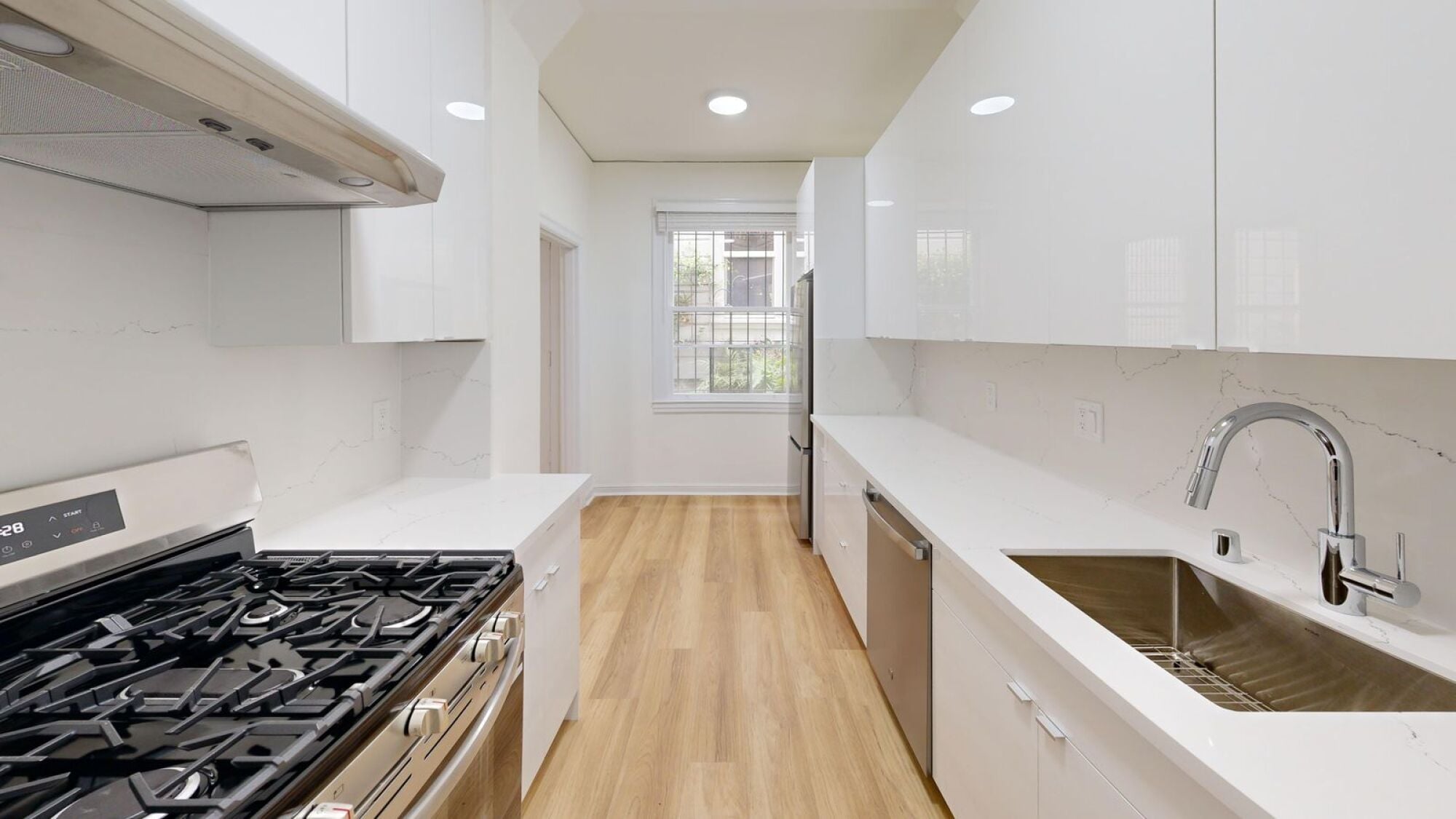 A modern kitchen with a black stove top and white cabinets.