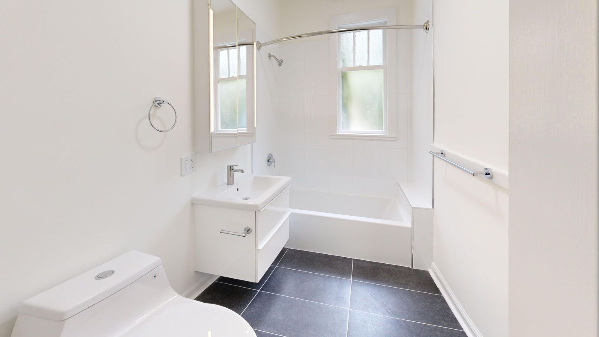 A white toilet sits next to a sink in a bathroom.