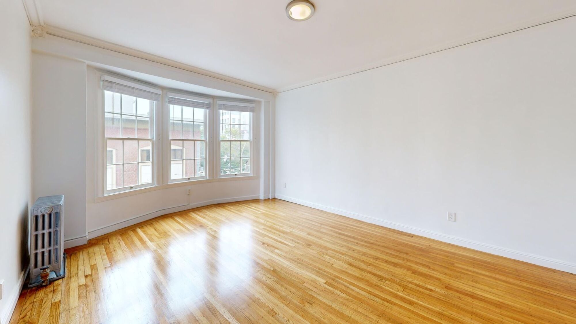 A room with a wooden floor and a large window.