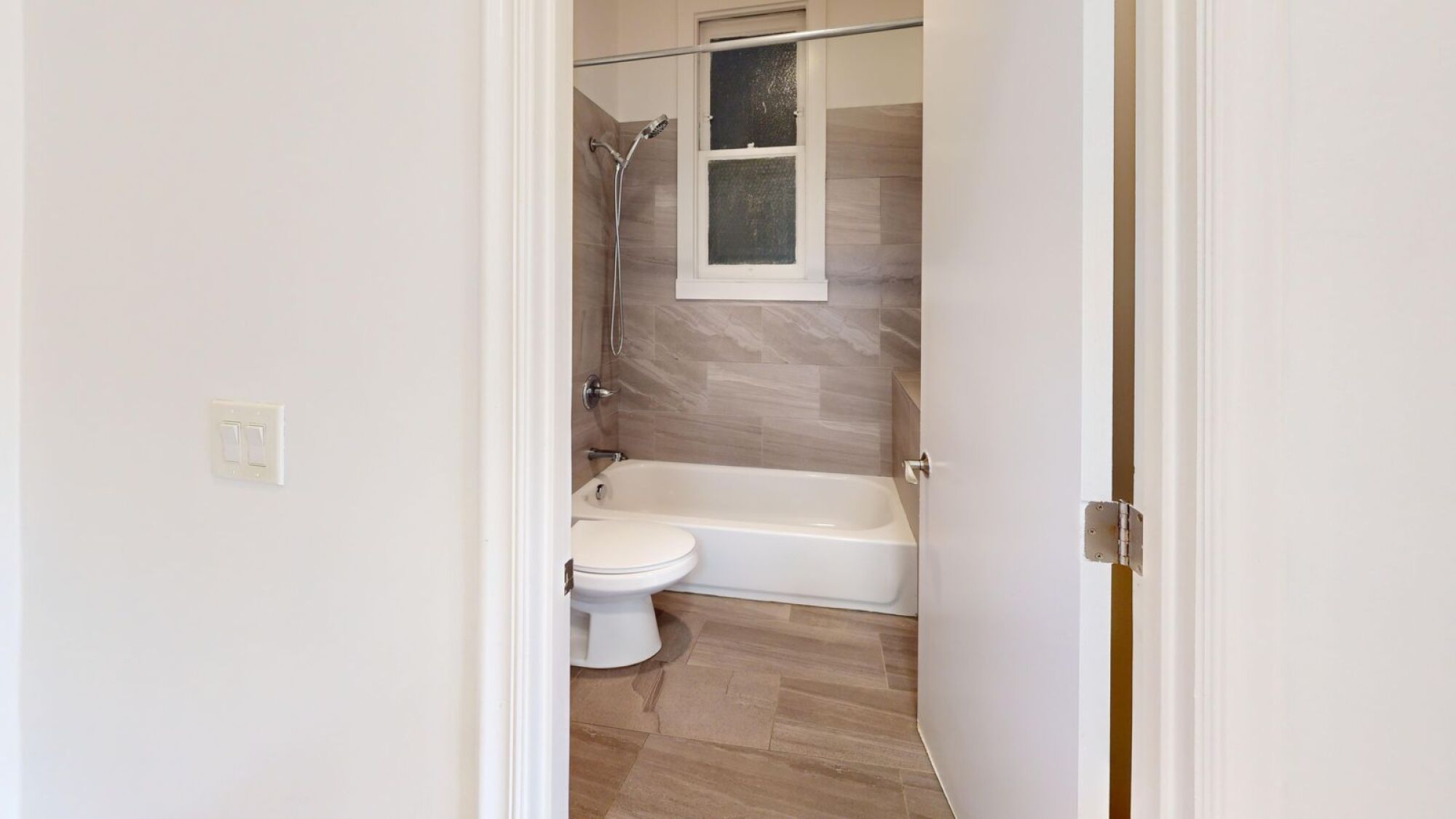 A white toilet sits next to a bathtub in a bathroom.