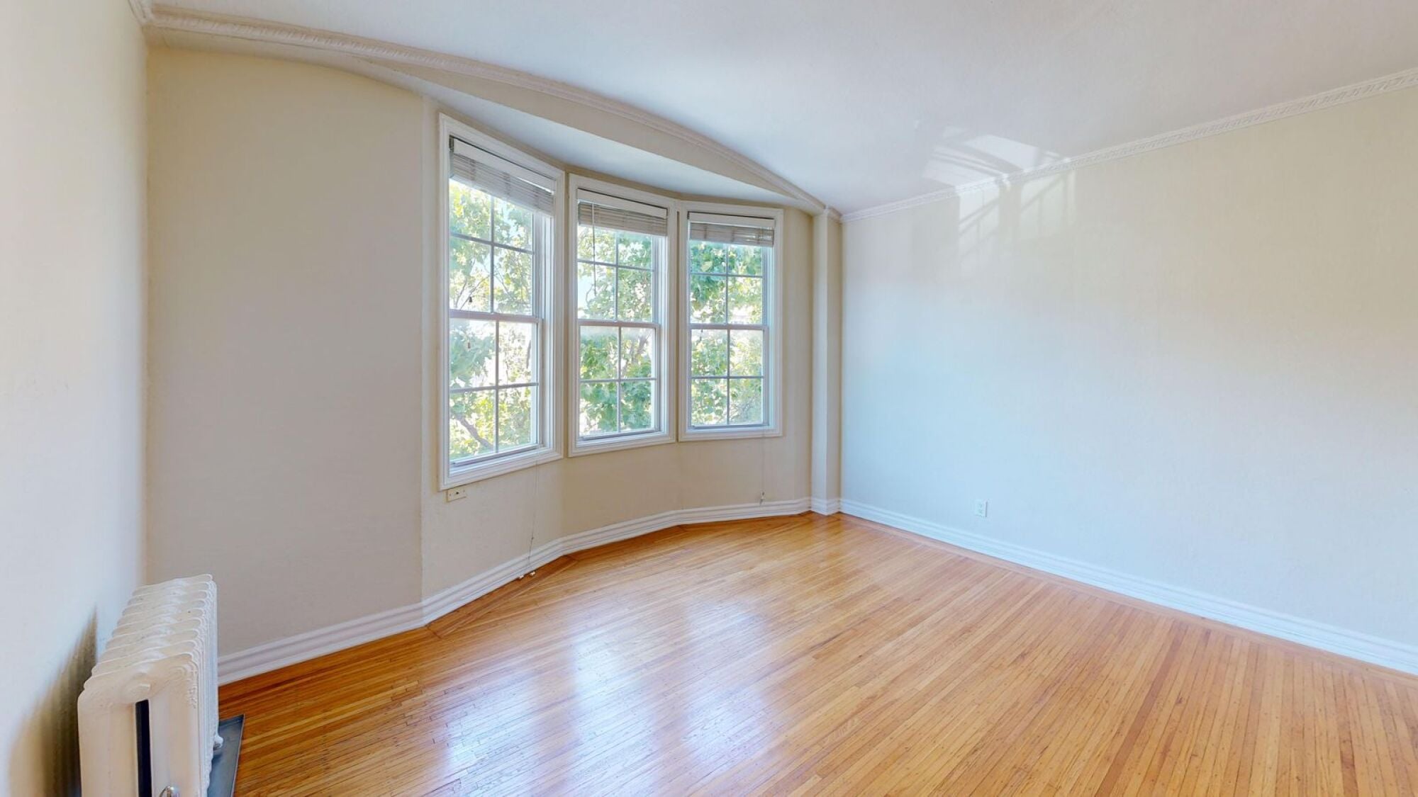 A room with a window and a radiator on the floor.