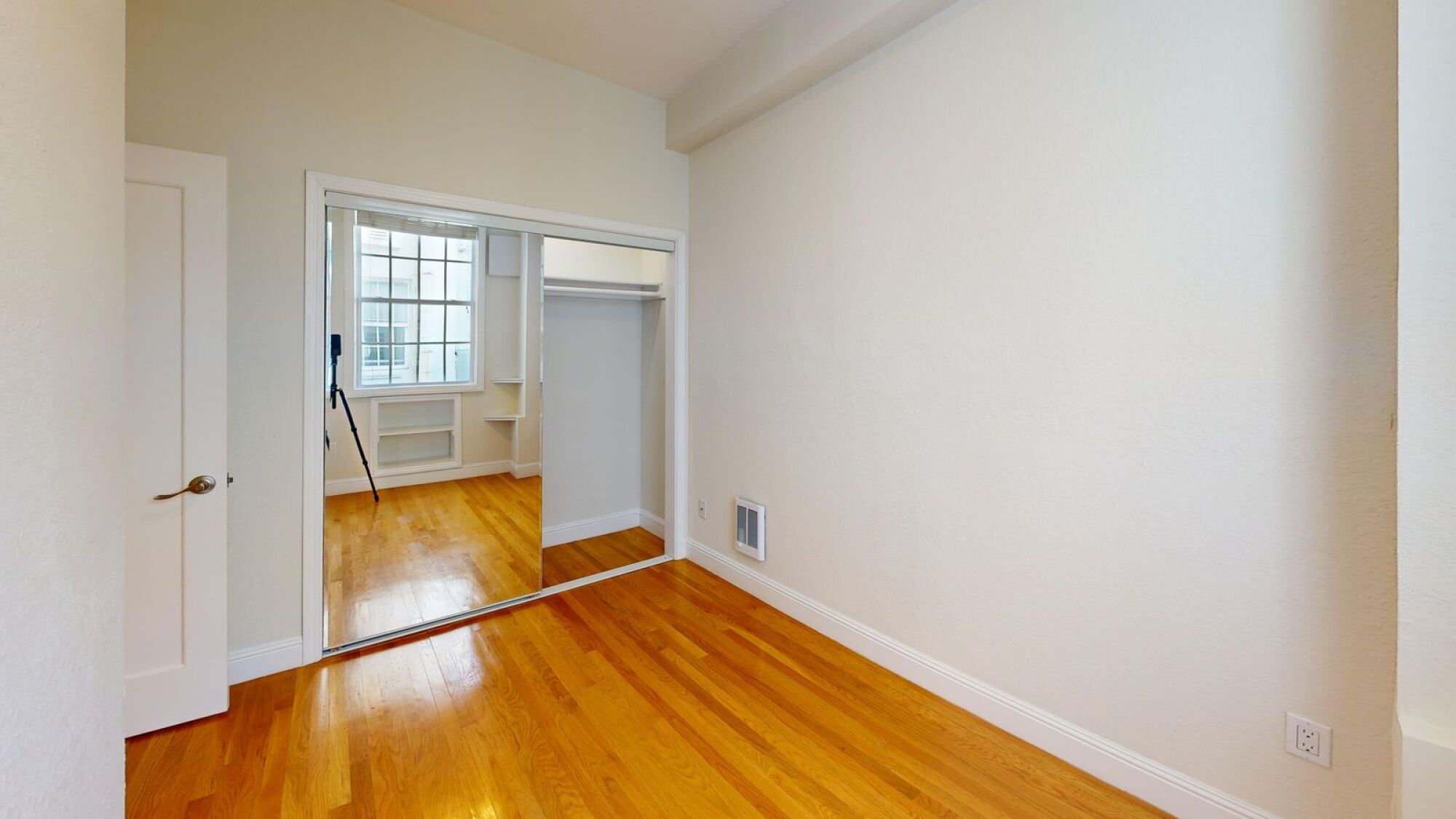A room with wooden floors and a white door.