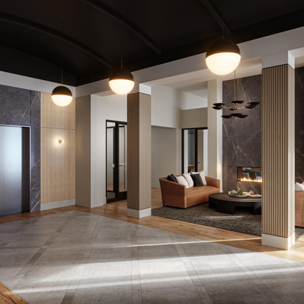 Modern lobby with pendant lights, brown sofa, fireplace, and neutral-toned walls and flooring.