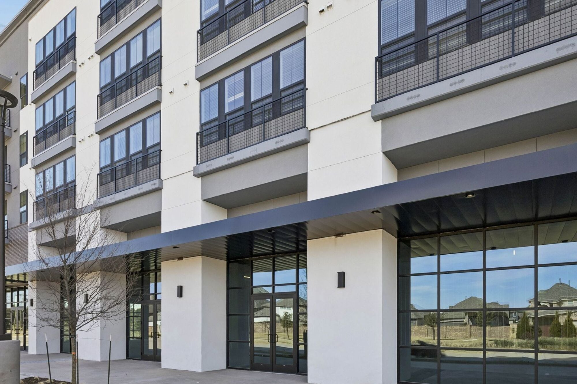 Front exterior view of The Elara in Farmers Branch, TX with clean architectural design and welcoming entry near Dallas
