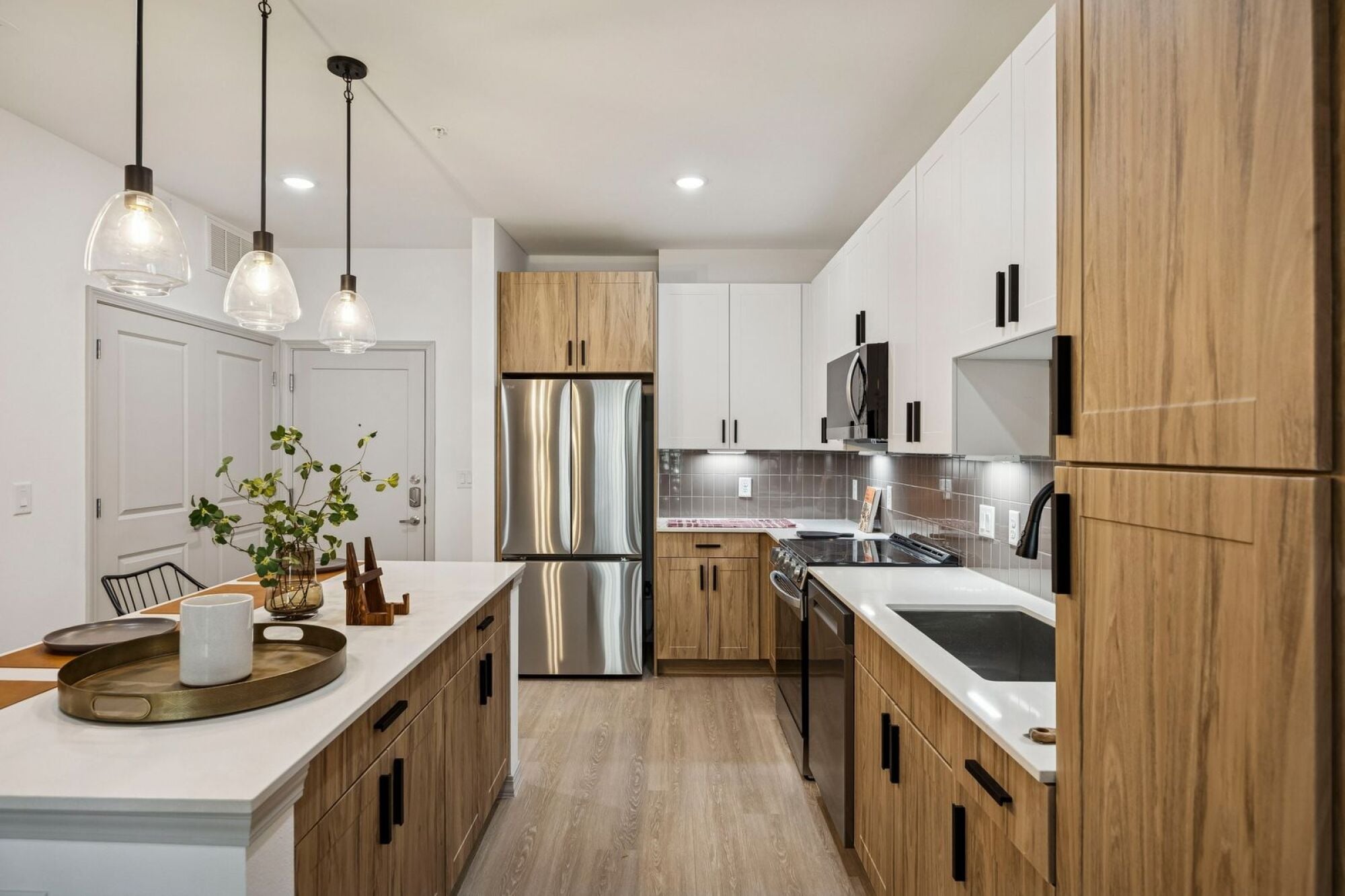 A luxurious kitchen with a large center island and two-toned cabinetry at The Elara in Farmers Branch, Texas.