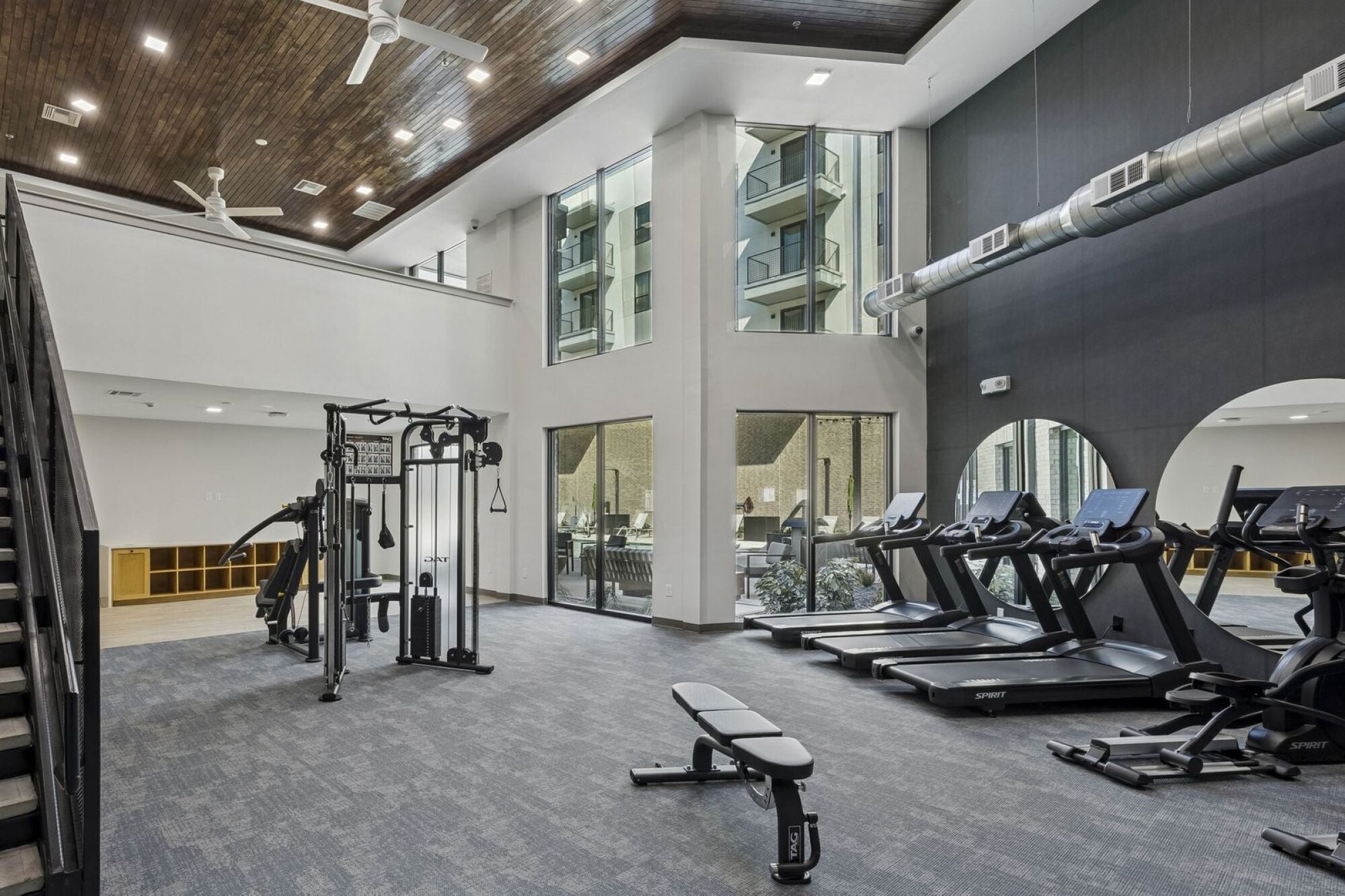 Modern two-story fitness center at The Elara Apartments near Dallas, TX offering premium resident wellness amenities in Farmers Branch, TX