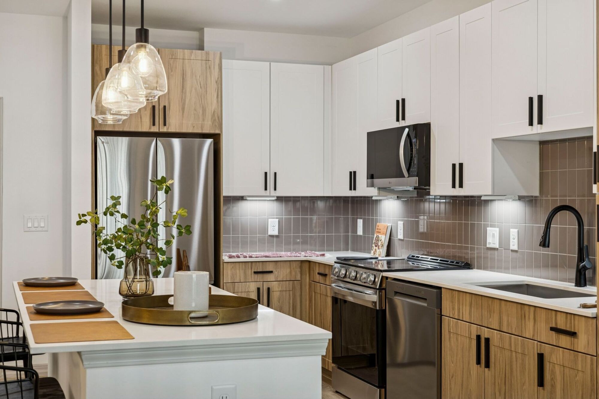 Modern kitchen at The Elara Apartments in Farmers Branch, TX featuring stainless steel appliances and sleek contemporary finishes near Dallas, TX