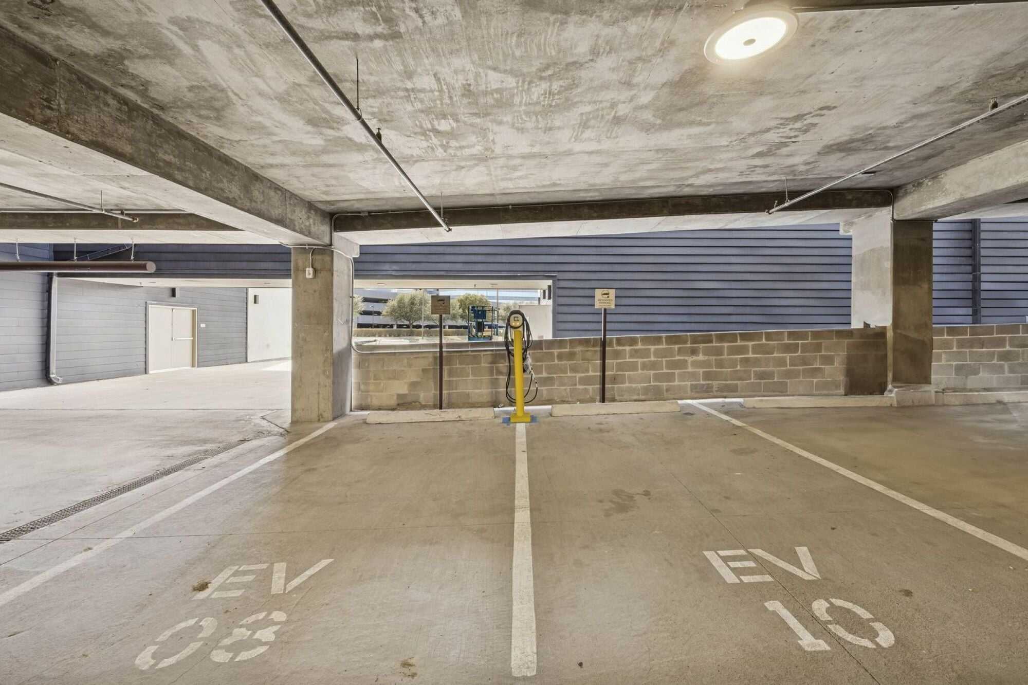 Parking garage at The Elara in Farmers Branch, TX providing covered resident parking near Dallas, TX