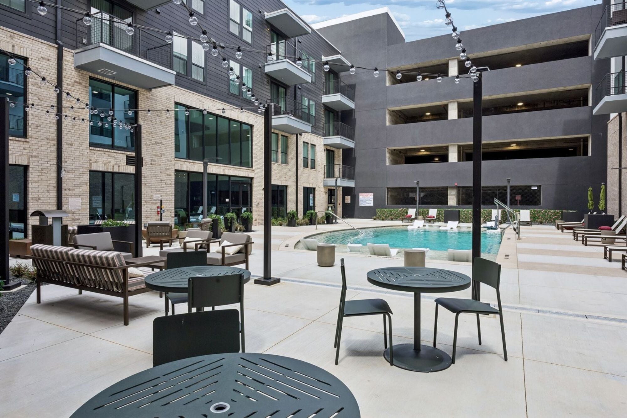 Modern pool deck at The Elara in Farmers Branch, TX with comfortable seating and relaxing loungers near Dallas