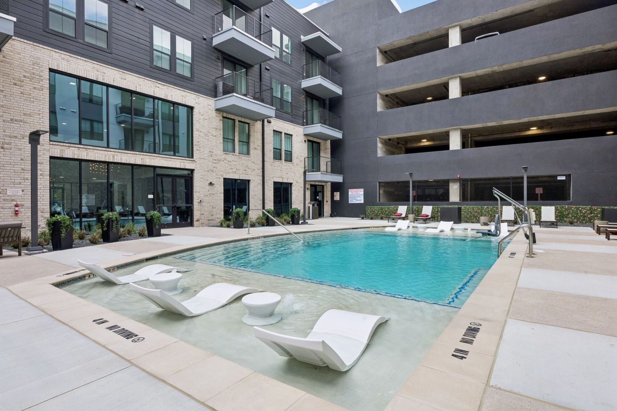 Luxury outdoor swimming pool at The Elara in Farmers Branch, TX with resort-inspired design and poolside loungers near Dallas