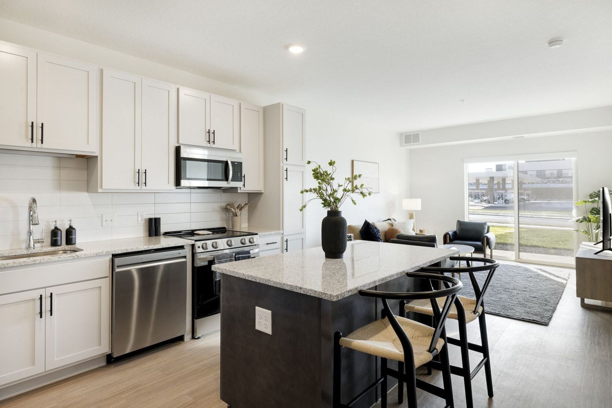 A modern kitchen with a large island and a view of the outdoors at The Blakeley in Shakopee, MN.