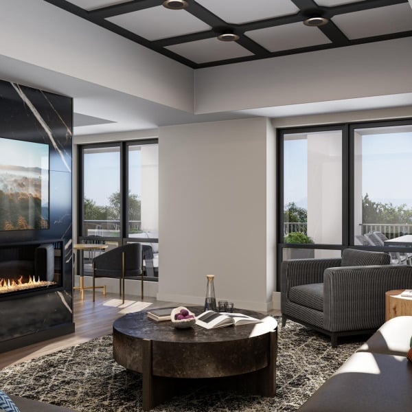 Modern clubroom with a fireplace, round coffee table, armchairs, and large windows letting in natural light.