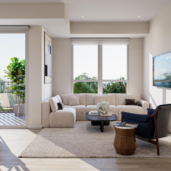 Bright living room with a beige sectional sofa, black chair, coffee table, and large windows overlooking greenery.