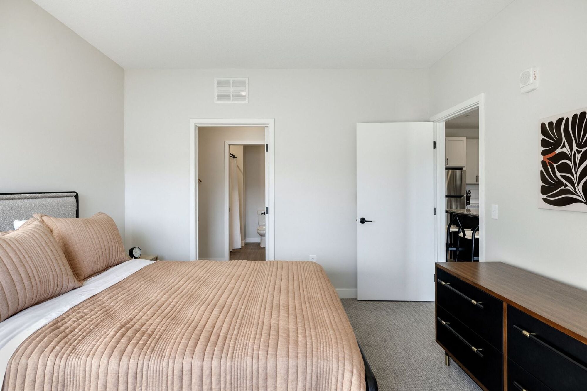 A bedroom with a large bed and a dresser at The Blakeley in Shakopee, MN.