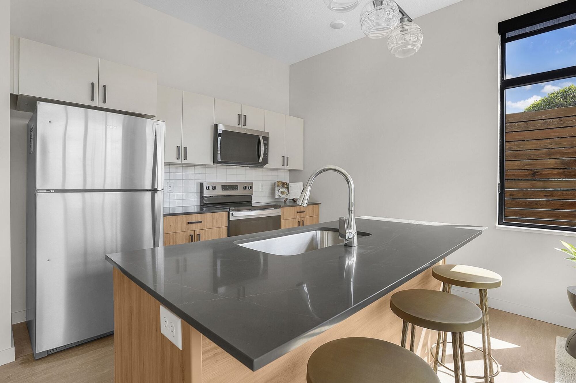 A modern kitchen with a large island and stainless steel appliances at The Whitney in Salt Lake City, Utah.