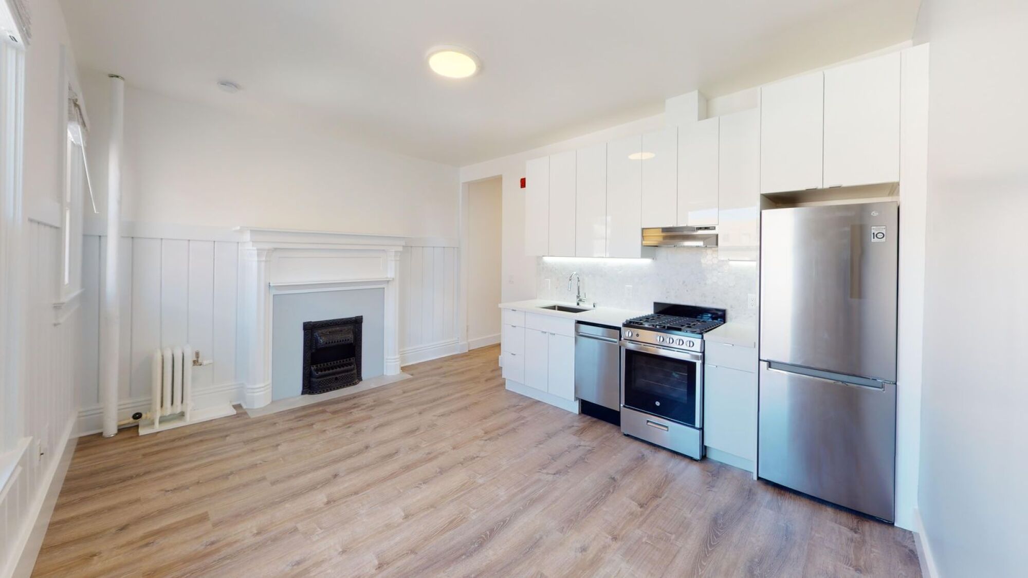 A kitchen with a stove top oven and a refrigerator.