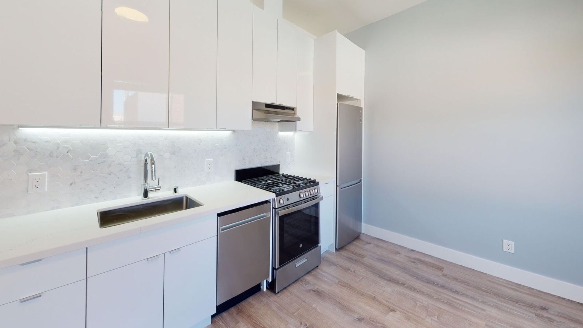 A kitchen with white cabinets and a stainless steel dishwasher.