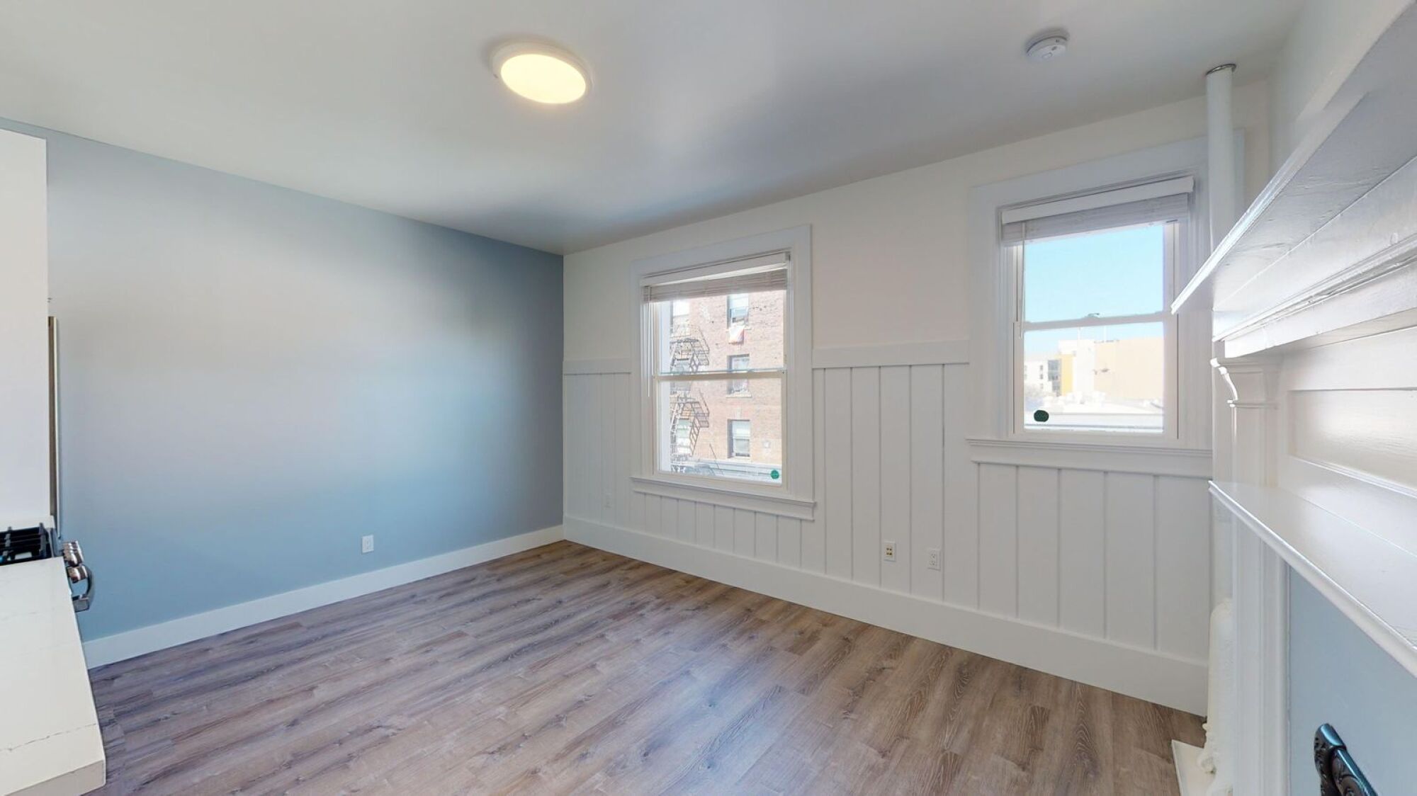 A room with a window and a wooden floor.