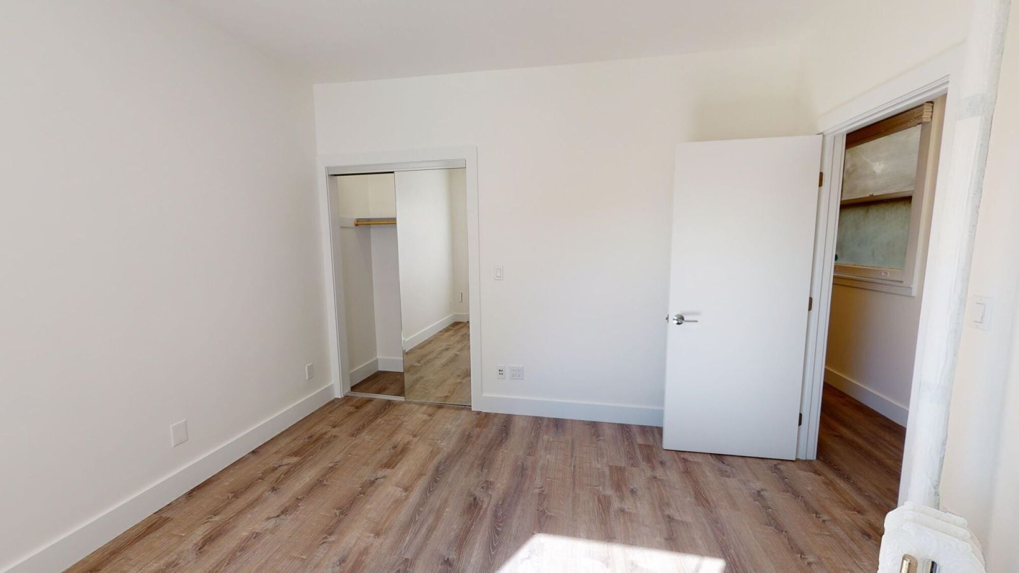 A room with a white door and a white wall.