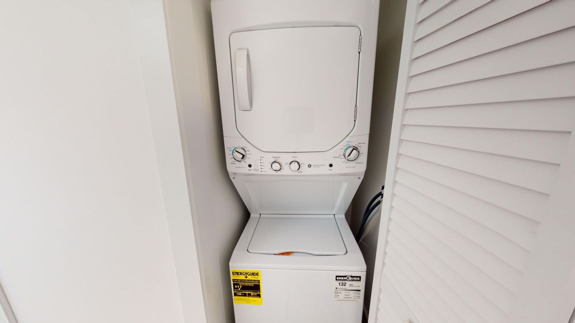 A white washing machine with a yellow sticker on the front.