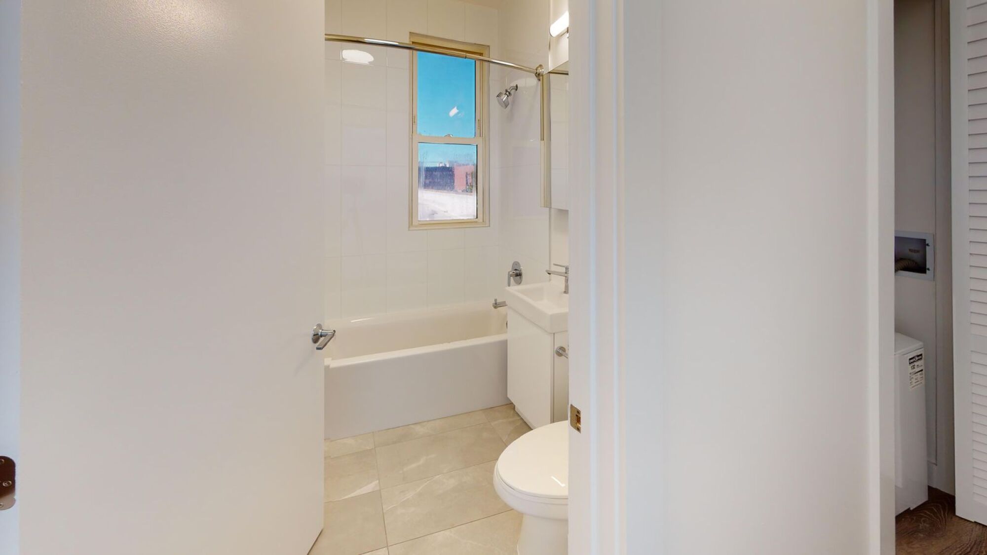 A white bathroom with a tub, toilet, and sink.