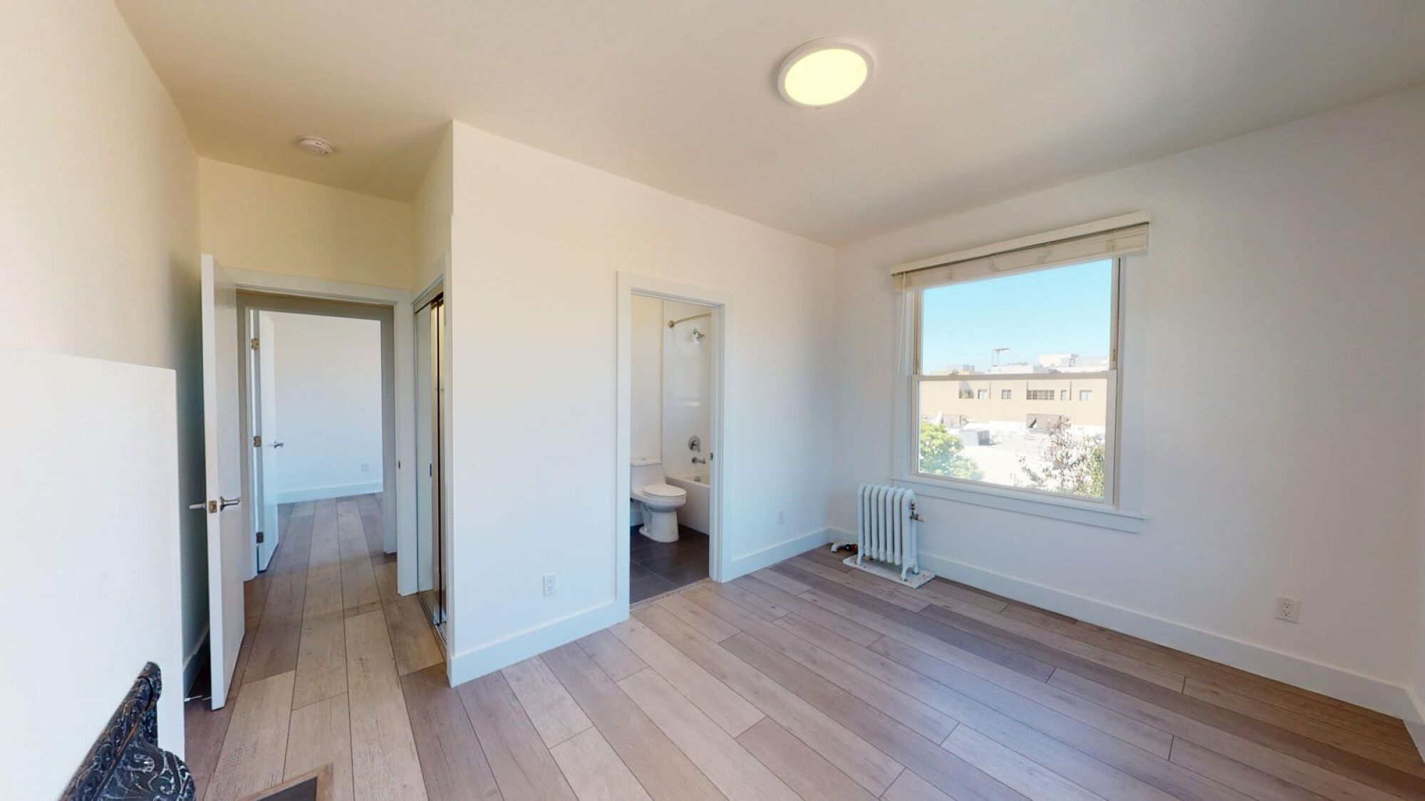 A room with a window and a radiator on the wall.