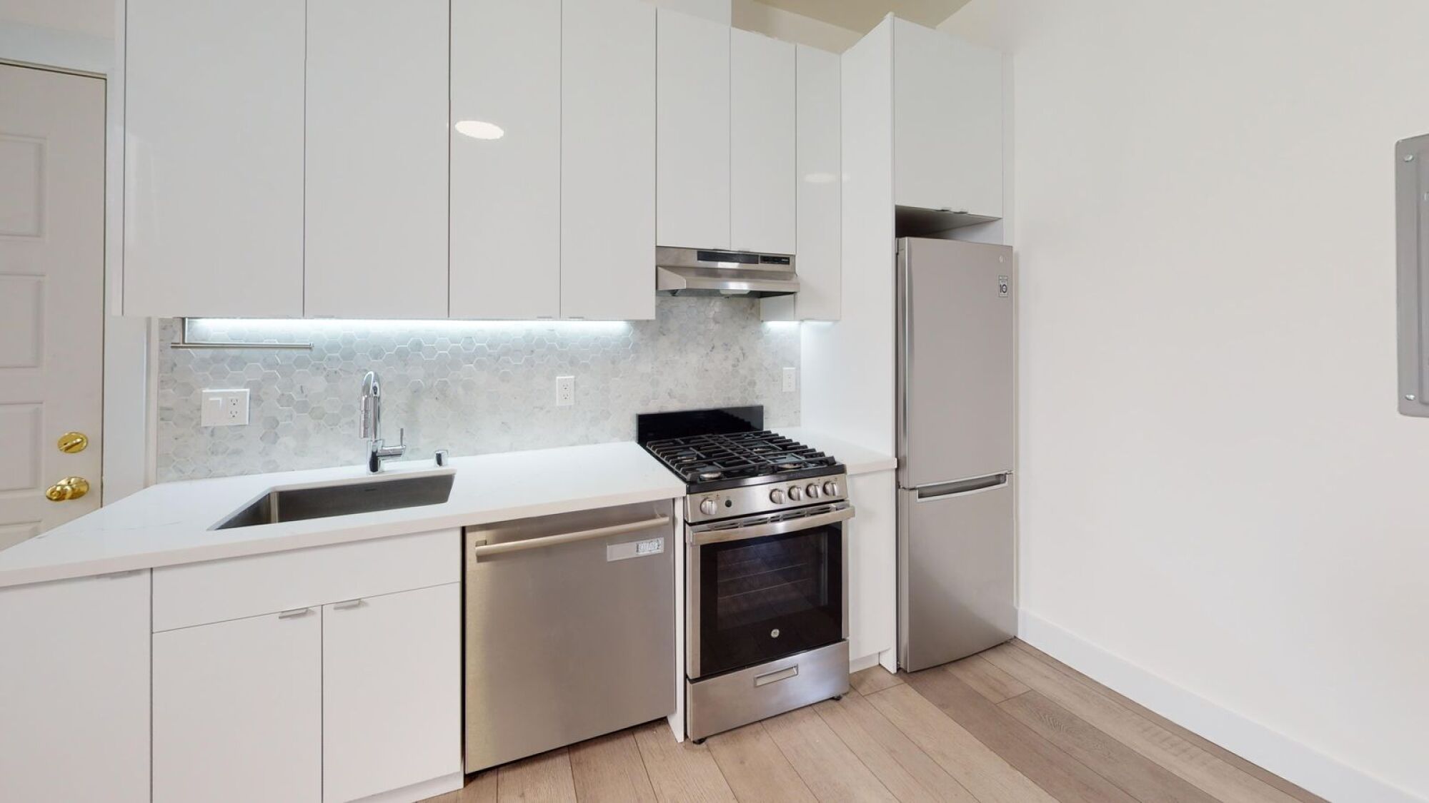 A modern kitchen with stainless steel appliances and white cabinets.