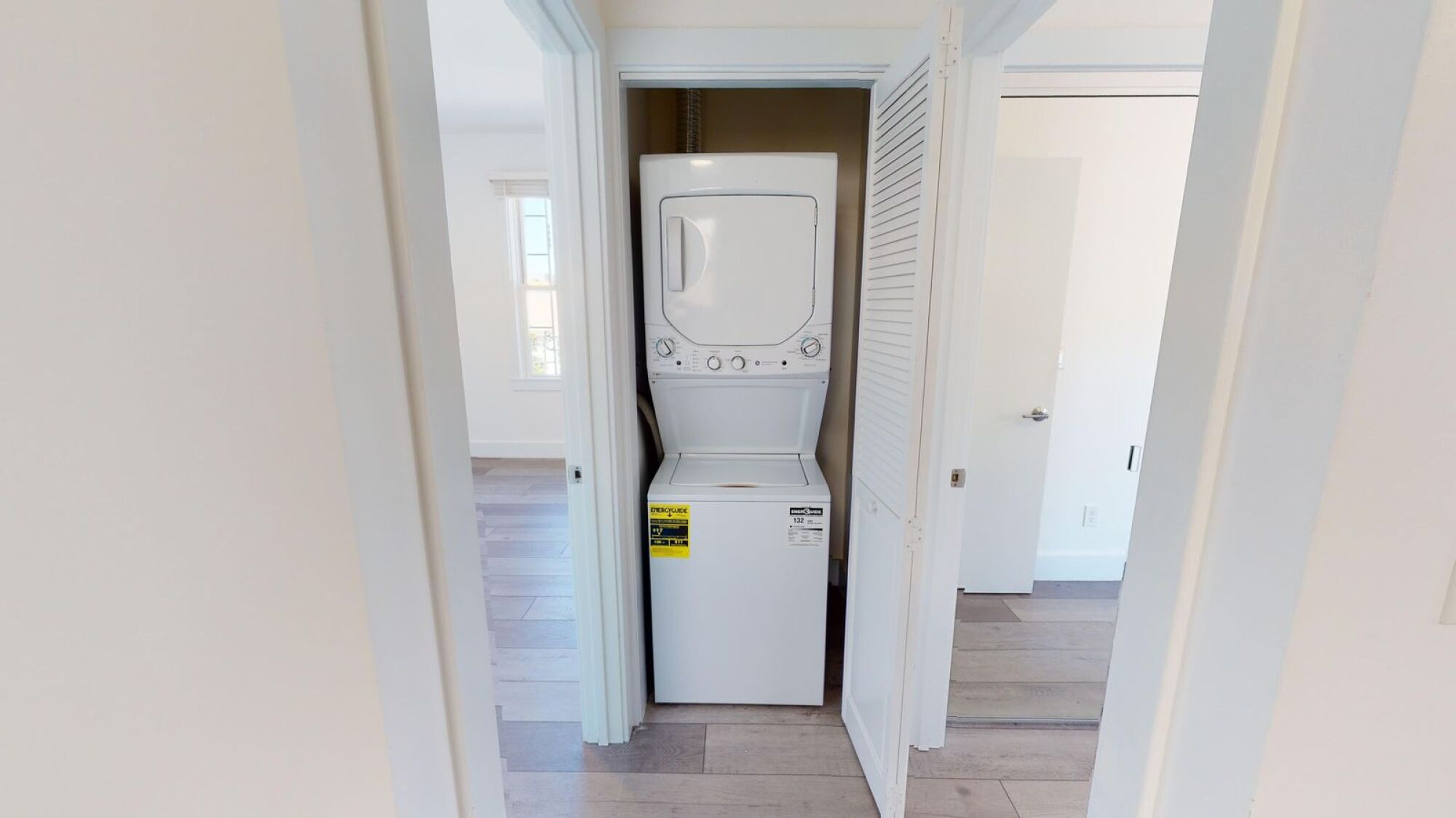 A white washing machine is in a small laundry room.