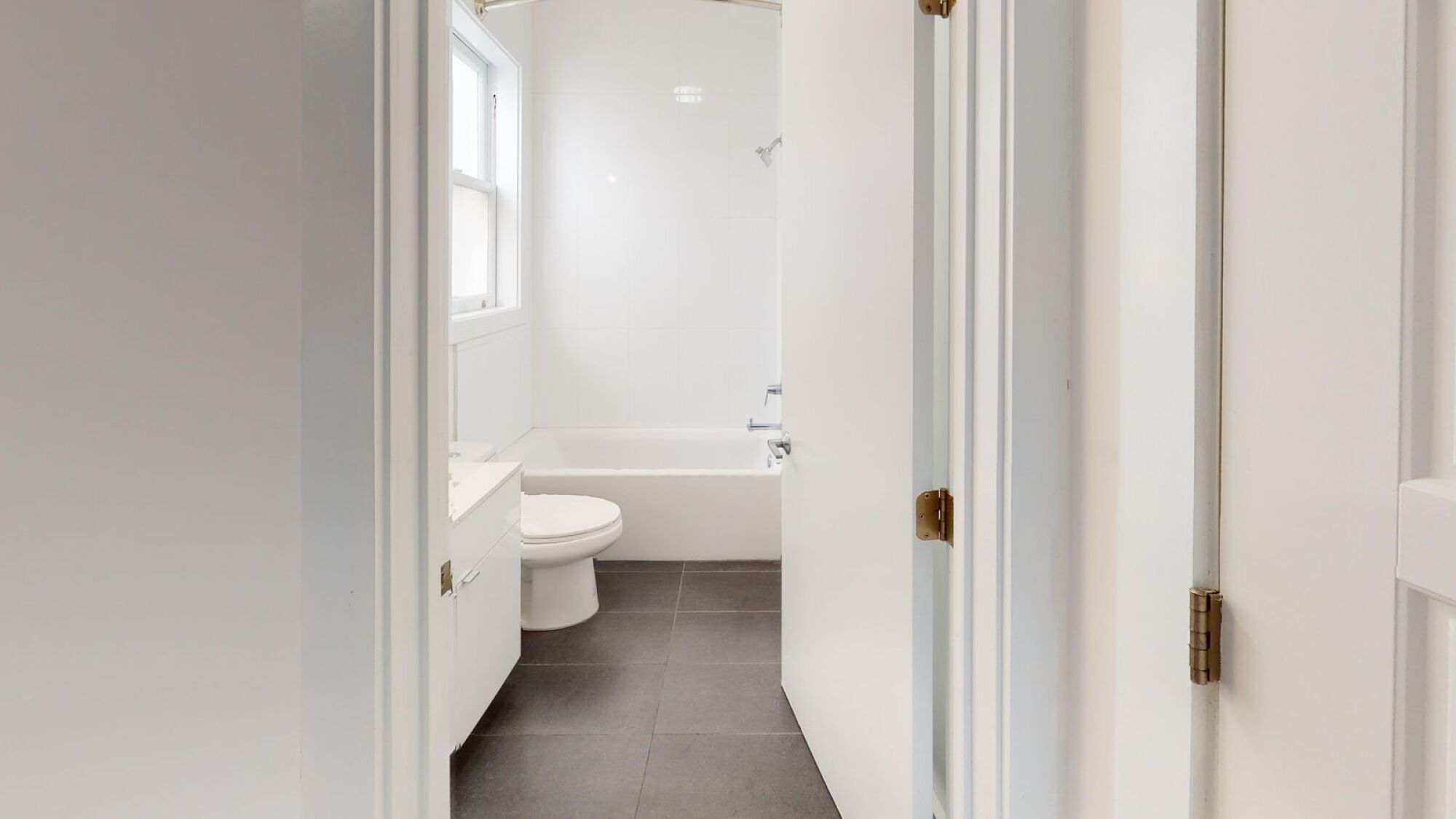 A white toilet sits next to a bathtub in a bathroom.