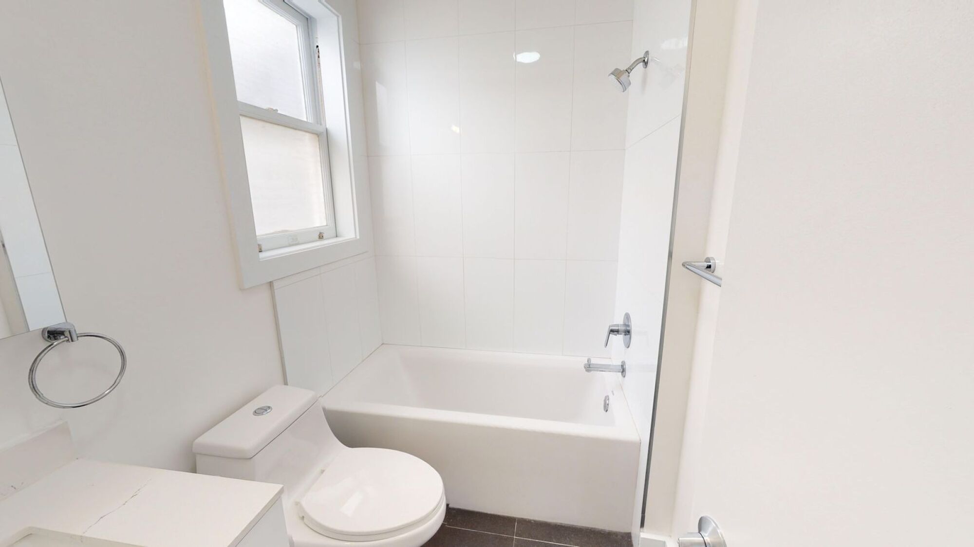 A white bathroom with a toilet, sink, and bathtub.