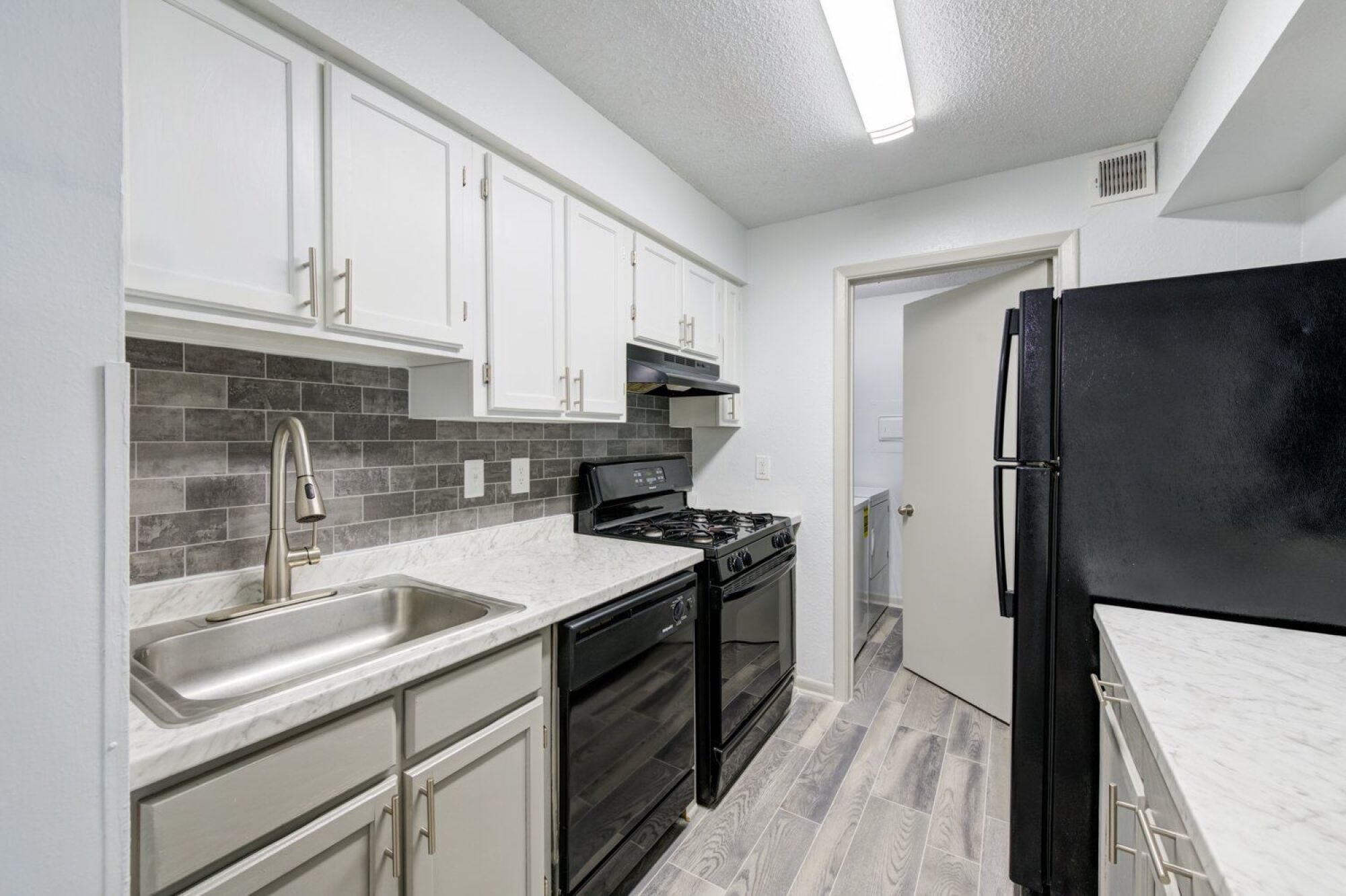 A kitchen with black appliances and white cabinets in Raleigh, NC