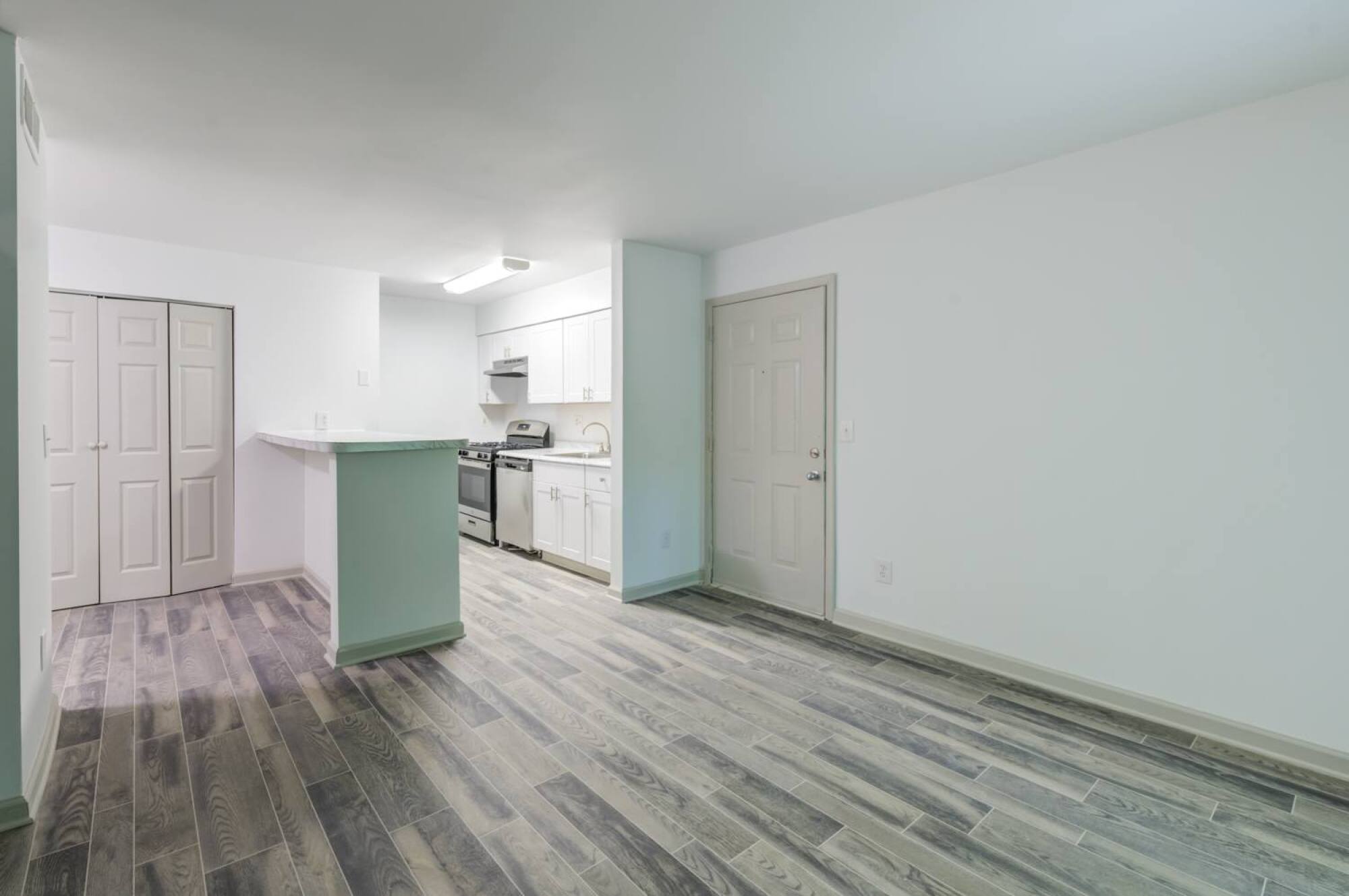A renovated kitchen and living room with luxury vinyl floors at Laurel Oaks in Raleigh, NC