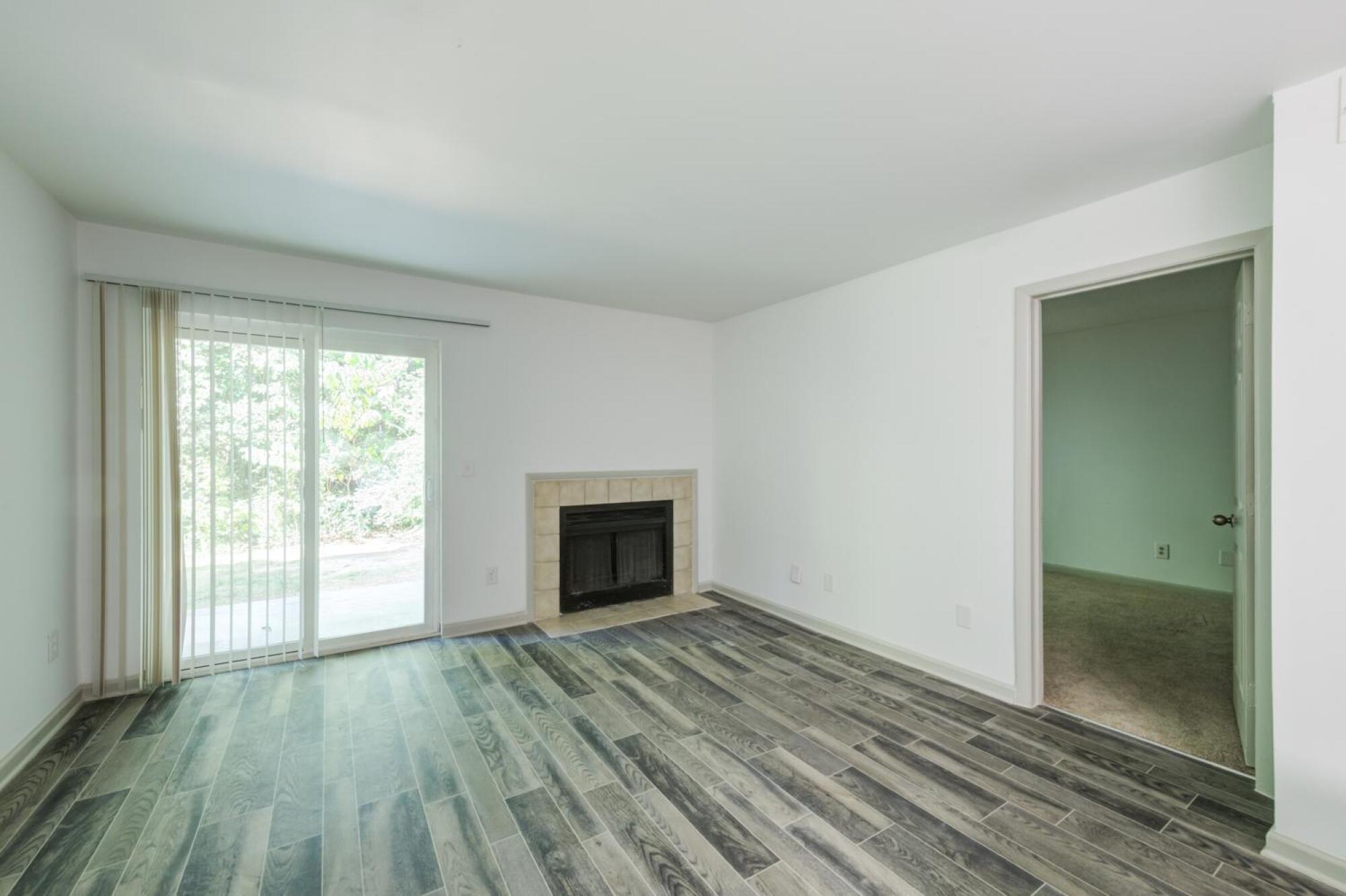Updated living room with a fireplace and sliding glass doors.